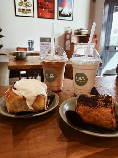 Cinnamon bun and cake served with two KULT. Gosforth iced drinks